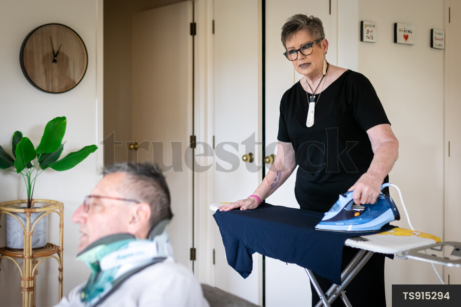 Health carer ironing clothes for patient