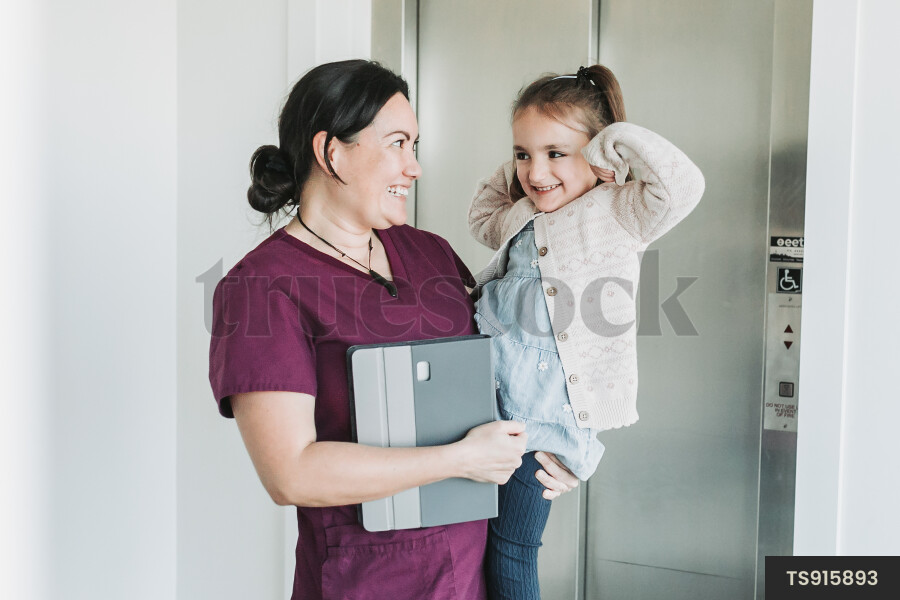 Dentist carrying patient by elevator in clinic