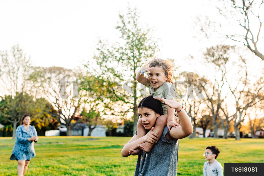 Girl giving piggyback ride to her brother in park