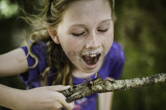 Girl Holding Stick with a Wētā on it