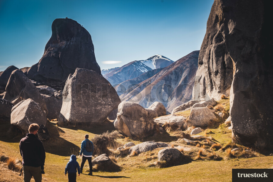 Group of people walking through ancient rocks weathered limestone in ...