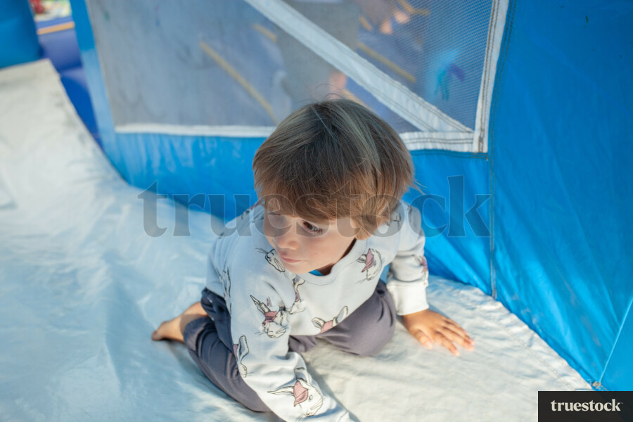 Child climbing and bouncing in the inflatable bouncy castle
