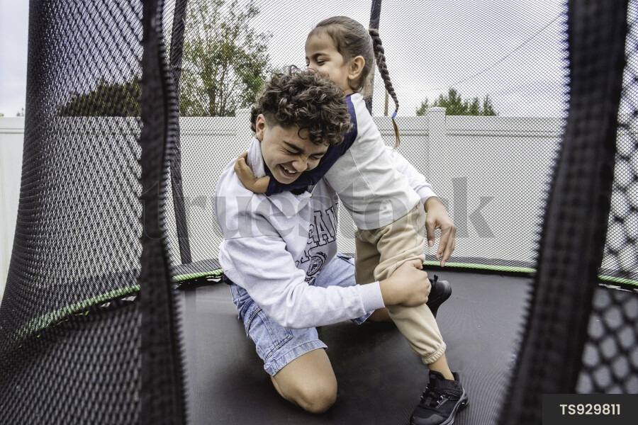 Brother and sister playing on trampoline