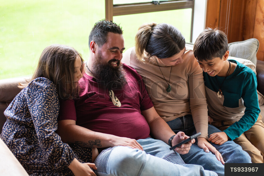 Family Using Phone on Couch