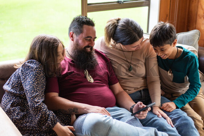 Family Using Phone on Couch
