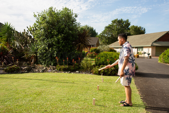Man playing kubb on lawn