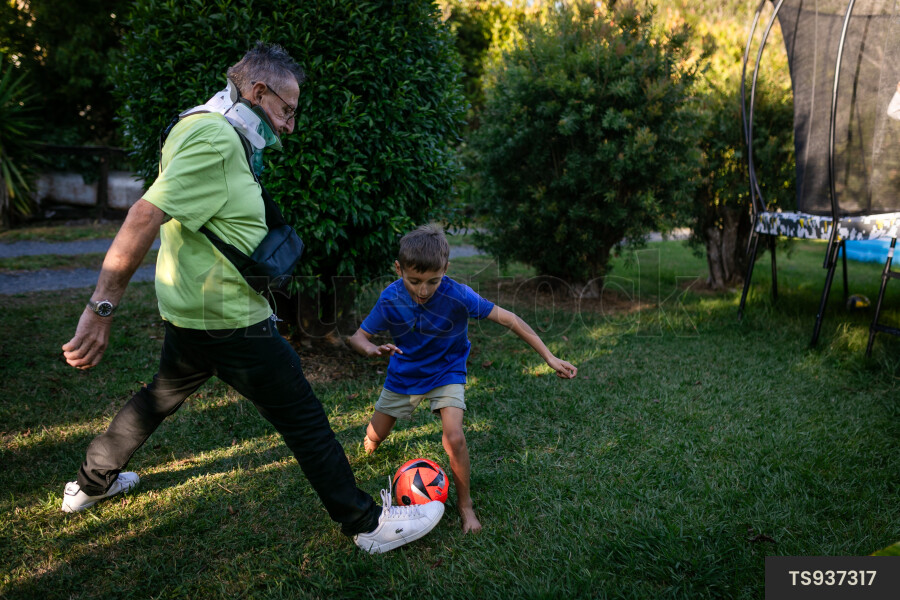 Man playing soccer with grandson