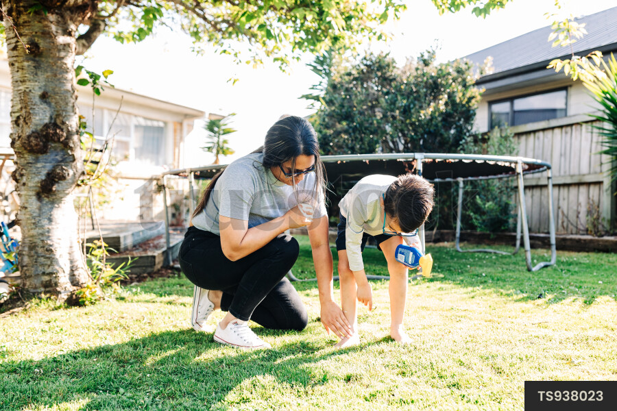 Woman helping her son apply sunscreen