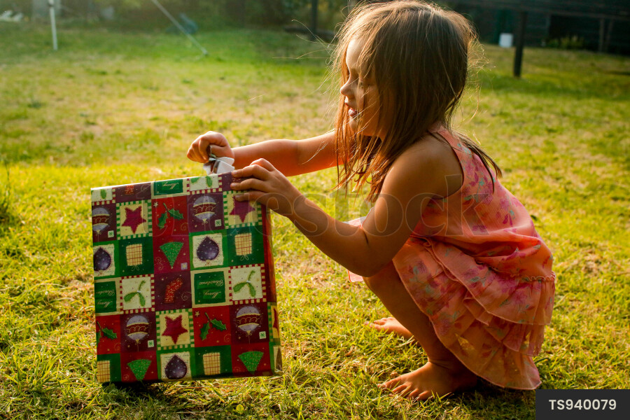Girl unwrapping Christmas present