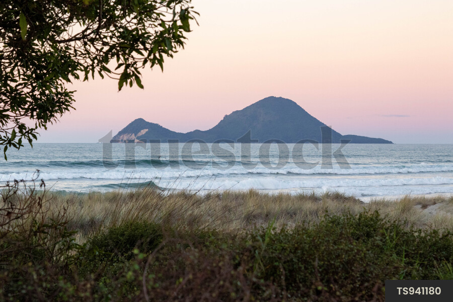 Waves in sea by coastline overlooking island