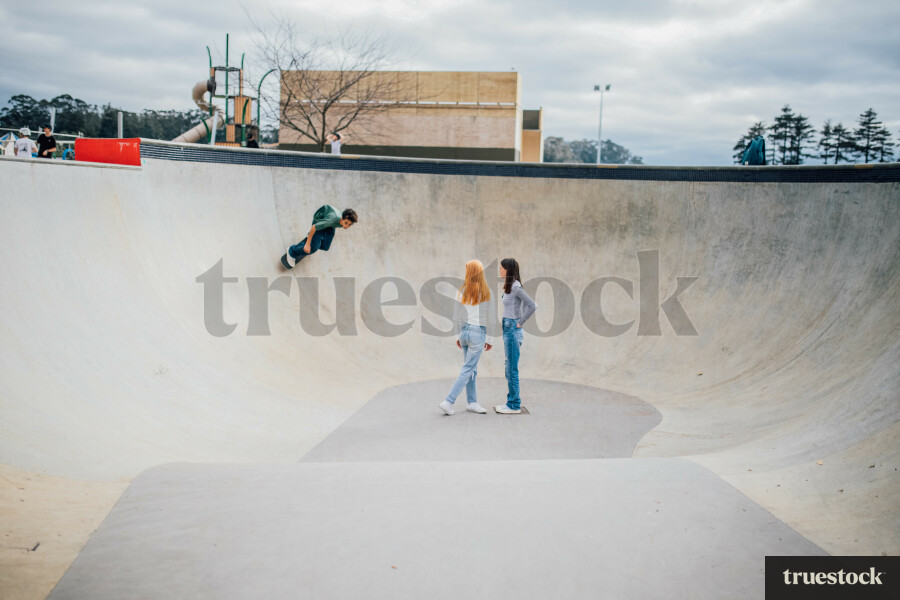 Teen Girls watching Boy Skateboard