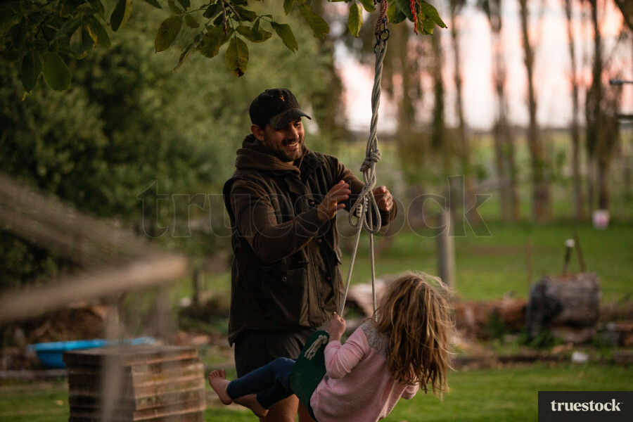 Father Pushing Daughter on Swing
