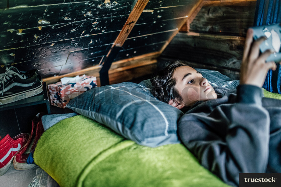 Boy lying on Bed playing Video Games