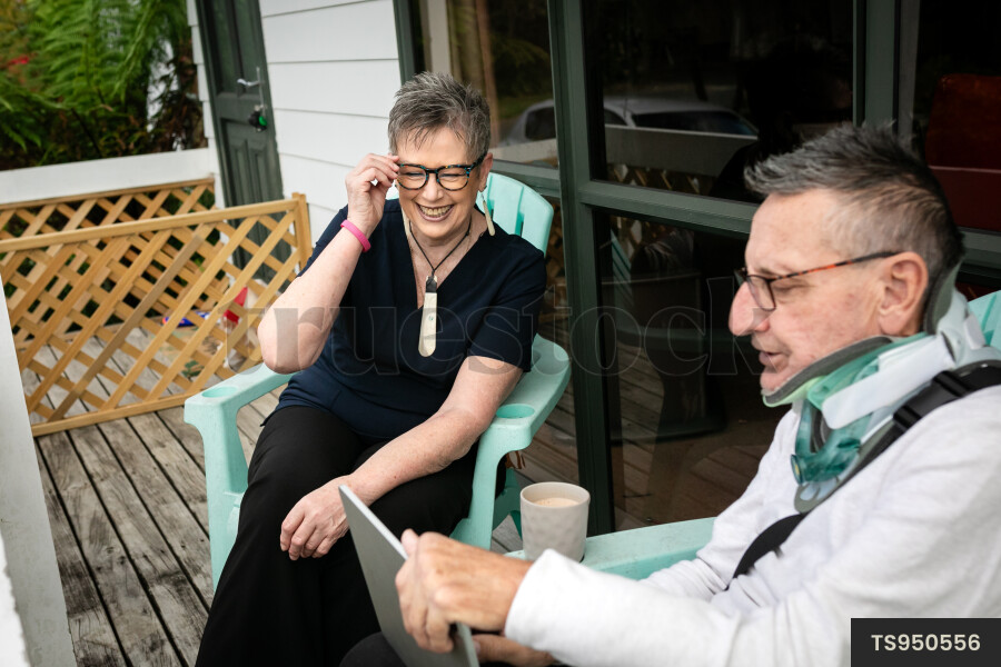 Health carer sitting with patient on deck
