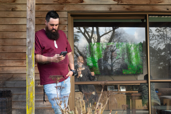 Man Using Phone on Porch