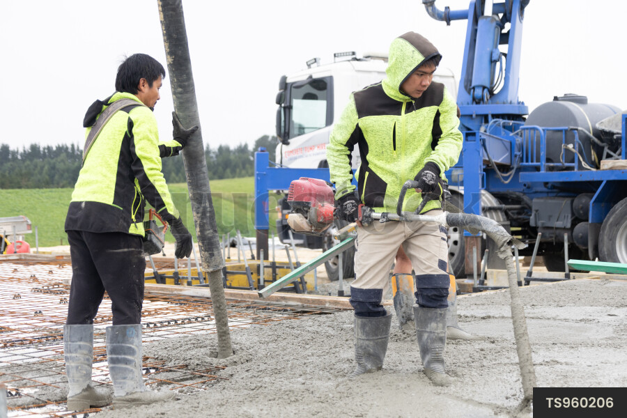Construction workers pouring concrete foundation