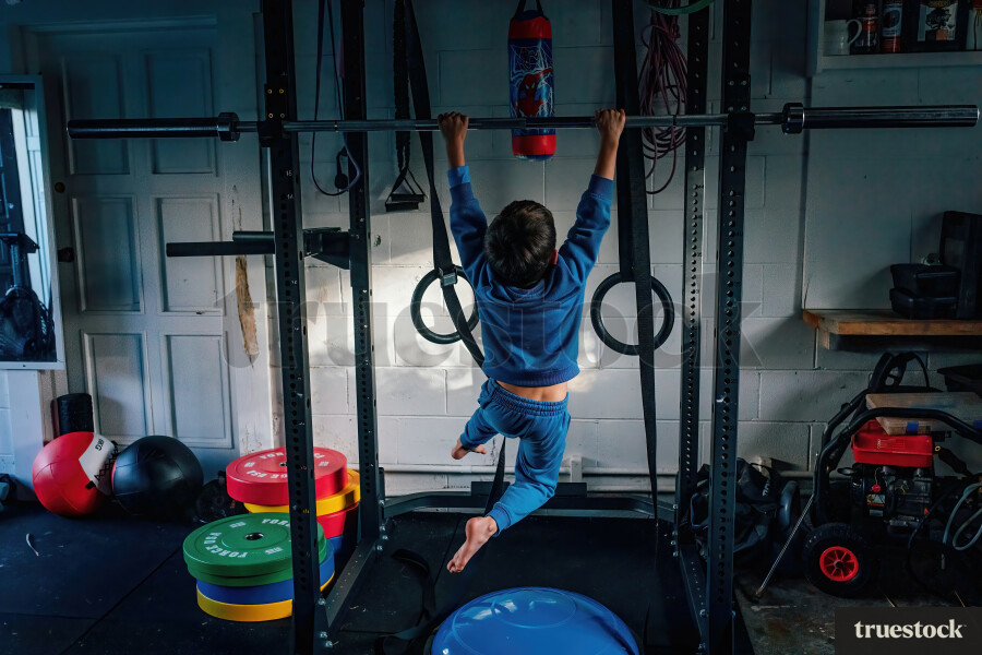 Young Boy Hanging on Exercise Equipment