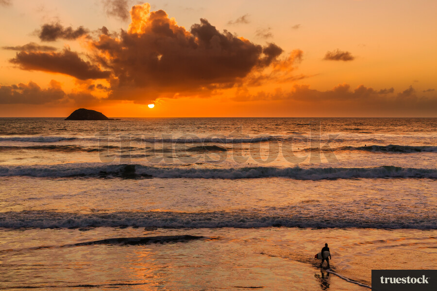 Muriwai beach at sunset with waves crashing