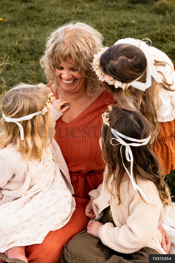 Smiling woman sitting with girls