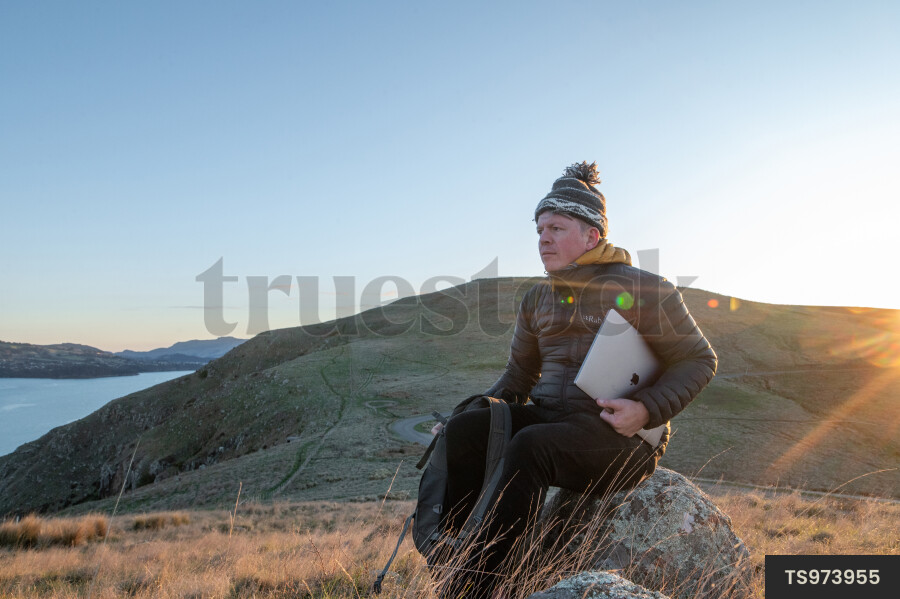 Man with laptop on rock