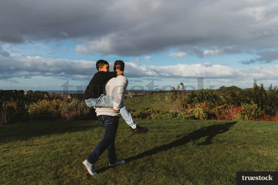 Dad giving son a piggyback outdoors in the backyard