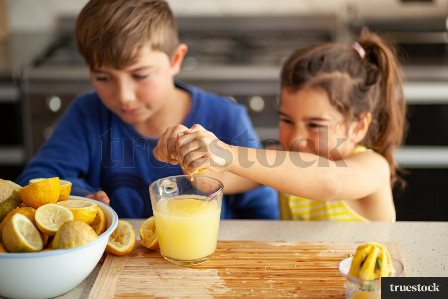 Young children making lemondade