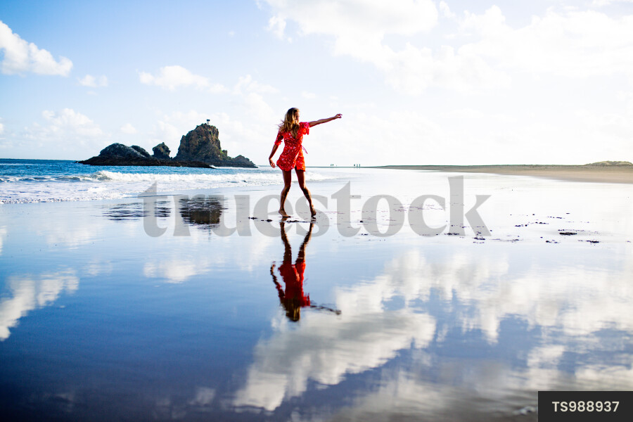 Woman on Whatipu Beach during sunset