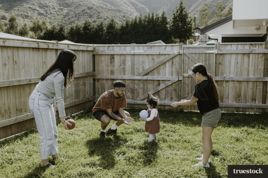 Family Playing with Ball in Yard