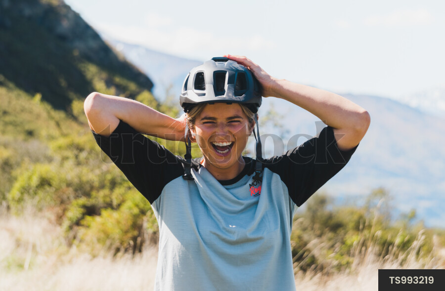 Woman with safety helmet smiling in native bush