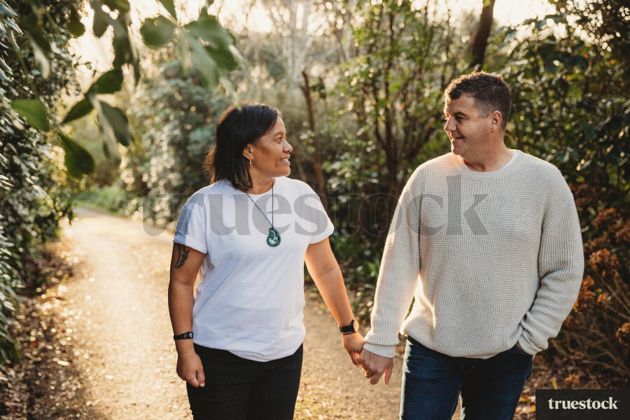 Portrait of happy married couple holding hands and walking while looking at each other
