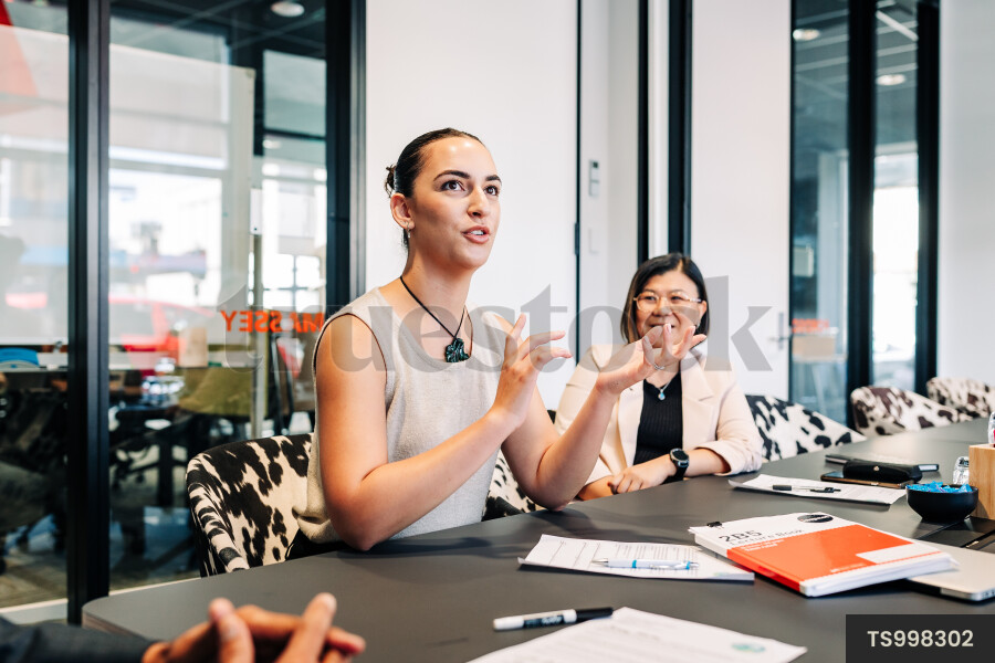 Businesspeople talking and gesturing during meeting in boardroom