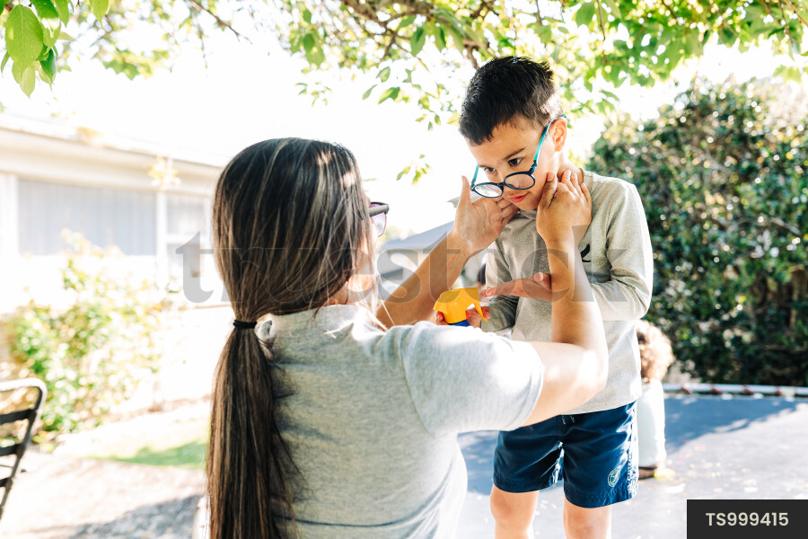 Woman helping her son apply sunscreen